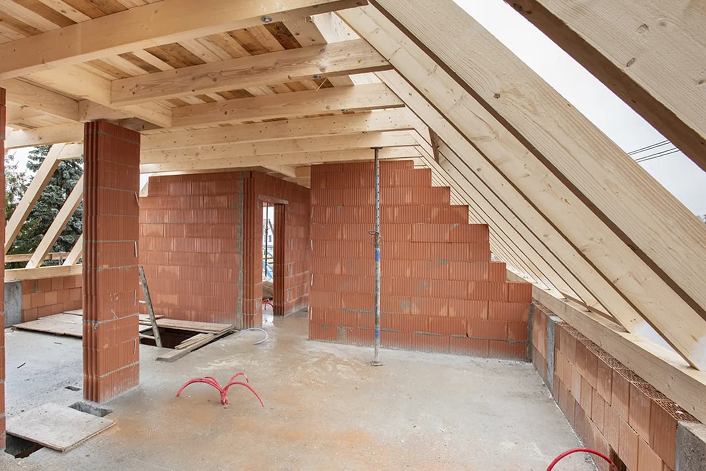 Dachstuhl aus Holz im Rohbau über gemauerten Wänden